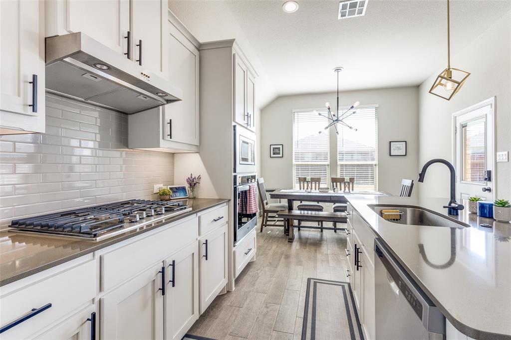 1829 Bellatrix Drive Haslet, TX 76052 - Photo 10 of 25 a kitchen with kitchen island granite countertop a stove and a sink