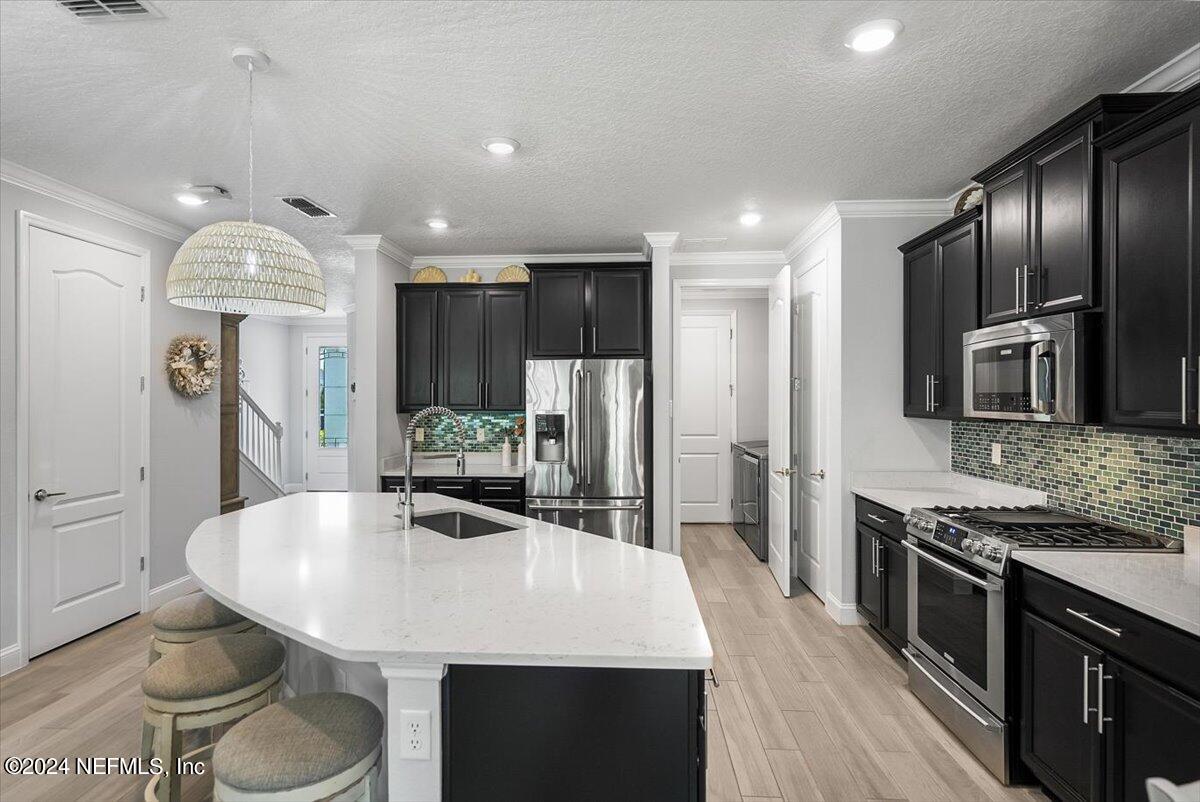 262 Clifton Bay Loop St. Johns, FL 32259 - Photo 12 of 57 a kitchen with stainless steel appliances granite countertop a sink a stove a refrigerator cabinets and wooden floor