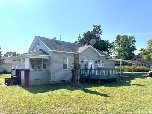 a view of a house with a yard and sitting area