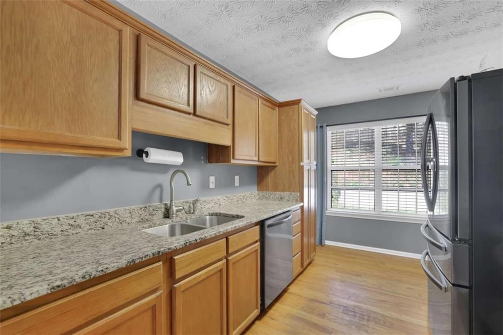 2932 Lake Hollow Road Gainesville, GA 30501 - Photo 17 of 68 a kitchen with granite countertop a sink stainless steel appliances wooden floor and a counter top space