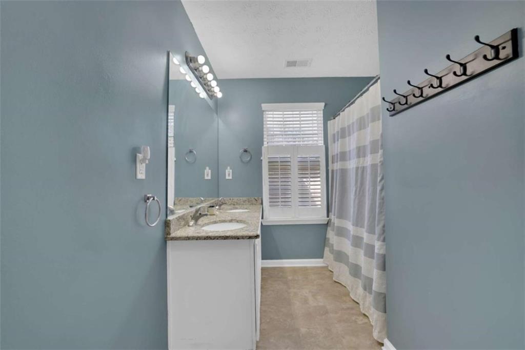 2932 Lake Hollow Road Gainesville, GA 30501 - Photo 39 of 68 a bathroom with a granite countertop sink a mirror and a shower