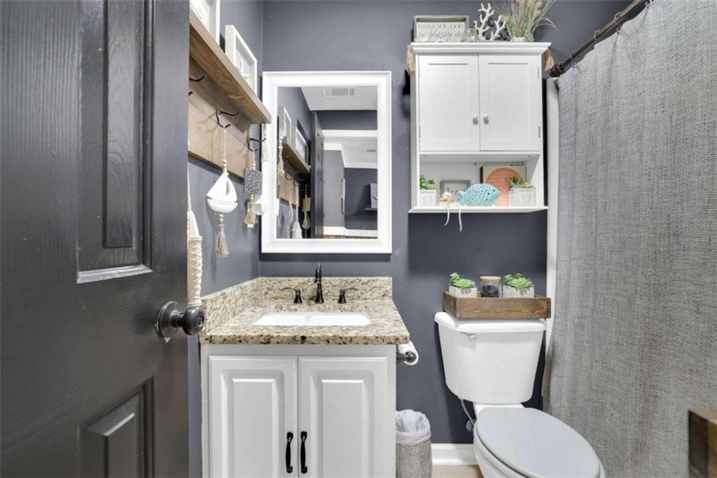 2932 Lake Hollow Road Gainesville, GA 30501 - Photo 46 of 68 a bathroom with a granite countertop toilet sink and mirror