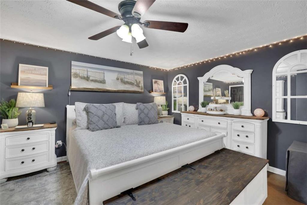 2932 Lake Hollow Road Gainesville, GA 30501 - Photo 50 of 68 a spacious bedroom with a bed a chandelier and a dresser