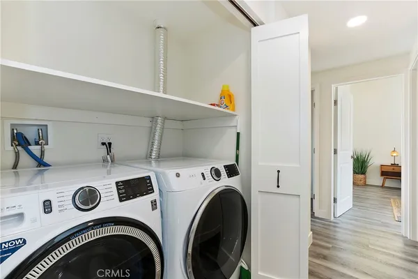 a view of washer and dryer with kitchen in the background