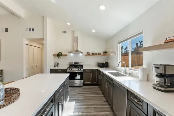 a large kitchen with stainless steel appliances lots of counter space and wooden floor