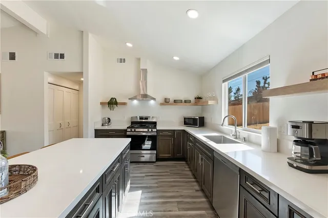 a large kitchen with stainless steel appliances lots of counter space and wooden floor
