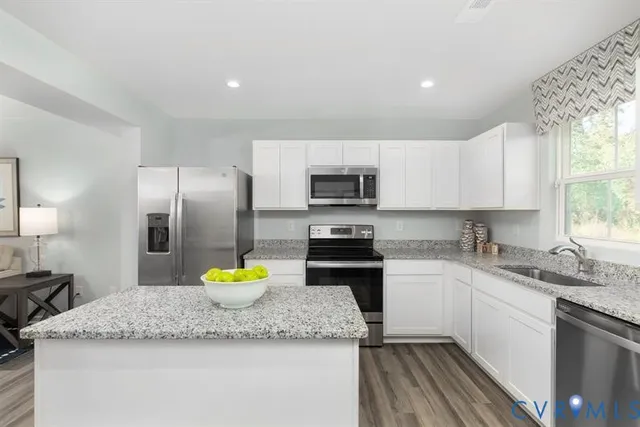 a kitchen with a sink a counter top space appliances and cabinets