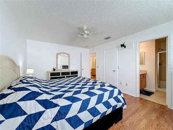 a bedroom with a bed lamps and wooden floor