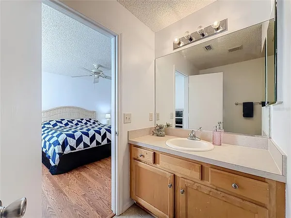 a view of a hallway with bathroom and wooden floor