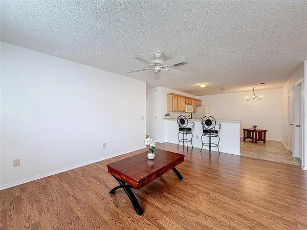 a living room with table chairs and wooden floor