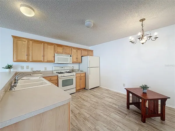 a kitchen with a refrigerator and white cabinets