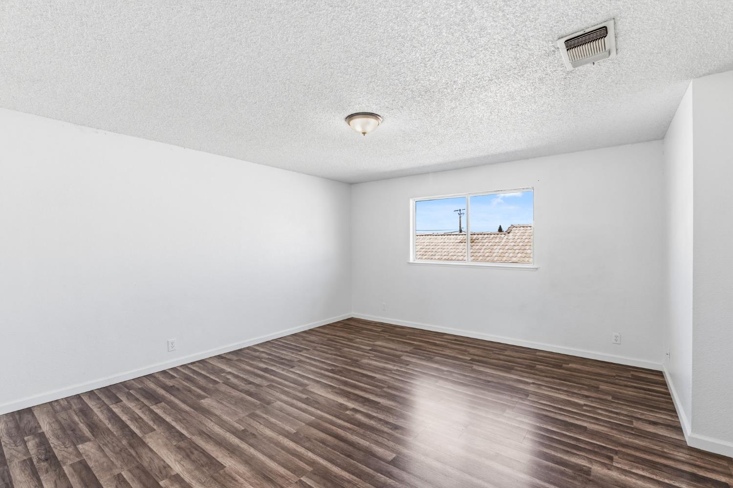 50 North 19th Avenue, Unit AF Lemoore, CA 93245 - Photo 16 of 40 an empty room with wooden floor and windows