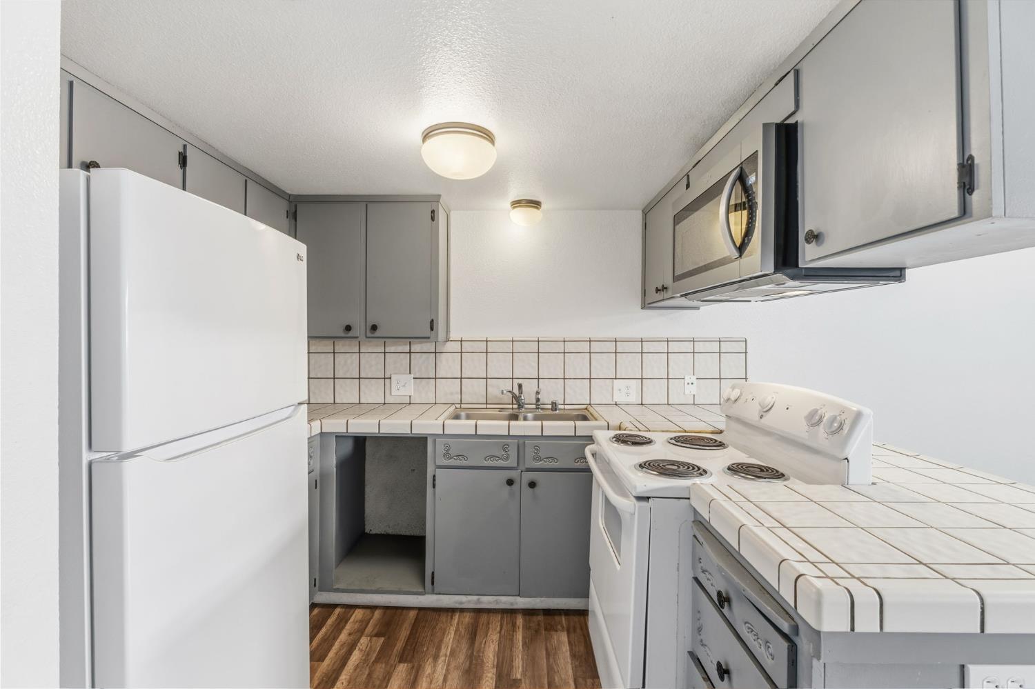 50 North 19th Avenue, Unit AF Lemoore, CA 93245 - Photo 5 of 40 a kitchen with a sink a refrigerator a washer and dryer