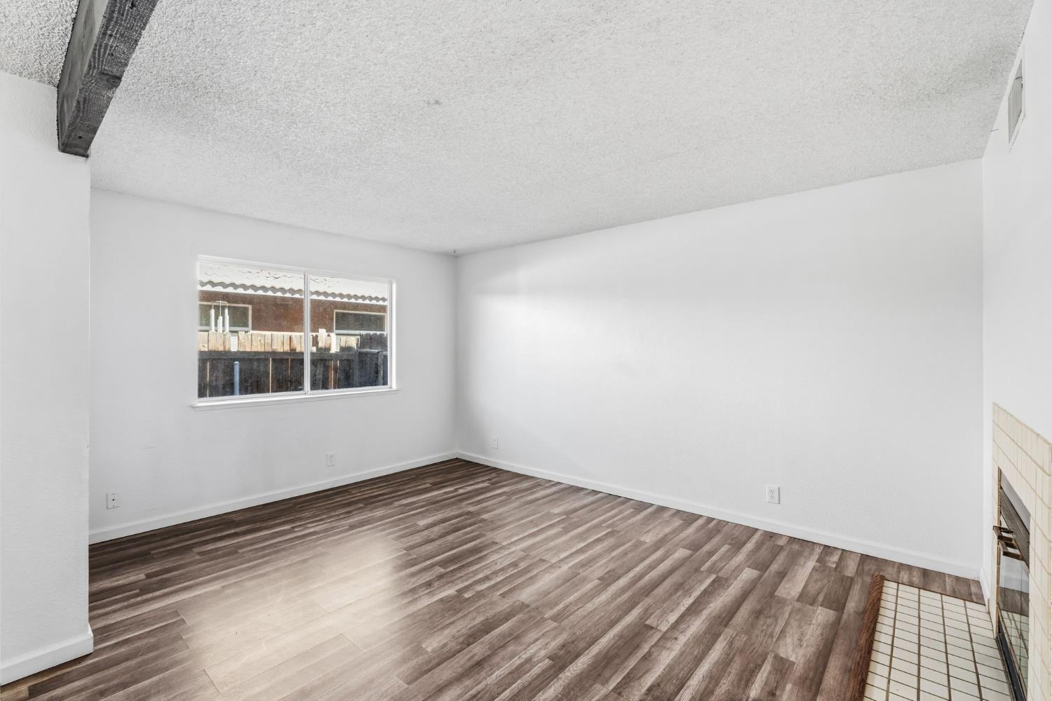 50 North 19th Avenue, Unit AF Lemoore, CA 93245 - Photo 10 of 40 a view of an empty room with wooden floor and a window