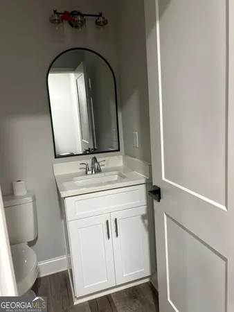 a bathroom with a granite countertop toilet sink and mirror