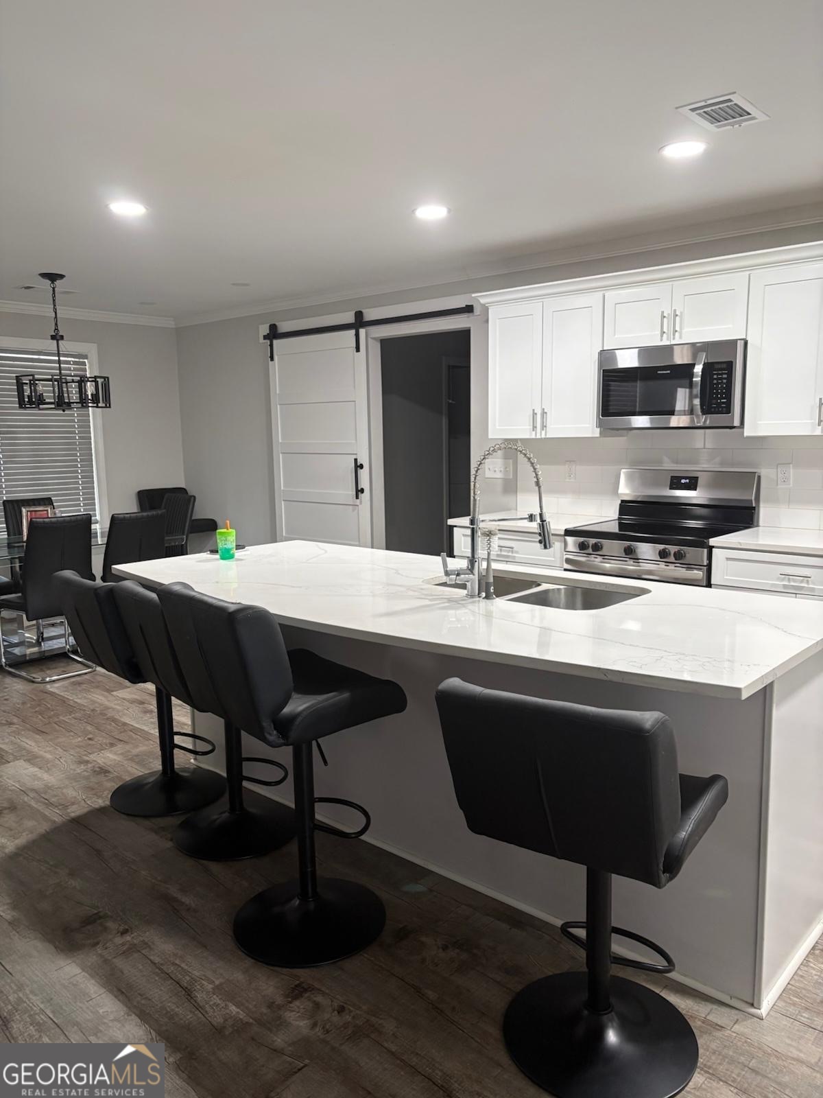 606 Old River Road Cornelia, GA 30531 - Photo 19 of 27 a kitchen with stainless steel appliances kitchen island granite countertop a sink table and chairs