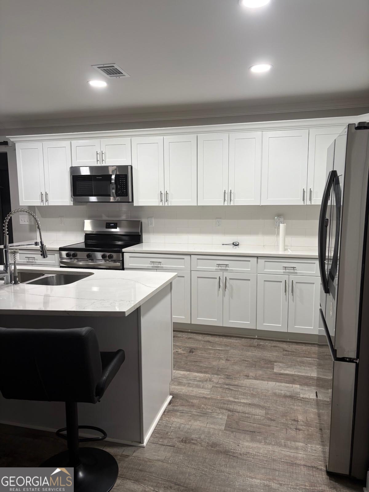 606 Old River Road Cornelia, GA 30531 - Photo 23 of 27 a kitchen with stainless steel appliances a stove a sink a microwave a refrigerator and cabinets