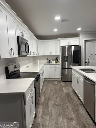 a kitchen with stainless steel appliances a refrigerator sink and microwave