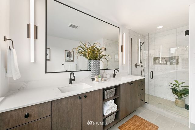 a bathroom with a double vanity sink a mirror and a shower