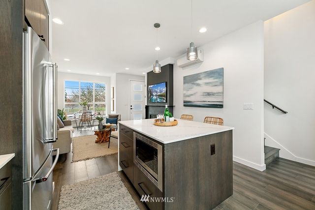 a kitchen with a stove a refrigerator and wooden floor