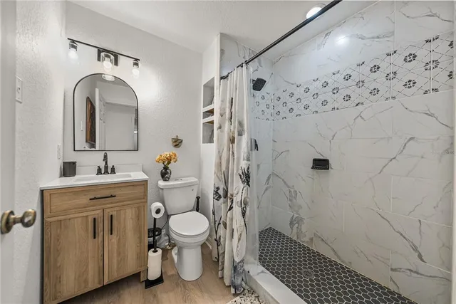 a living room with furniture a flat screen tv and a table