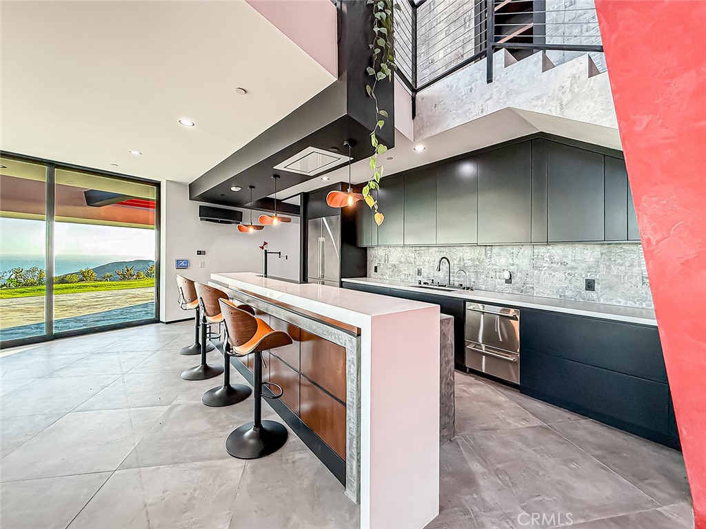 2514 Cayman Road Malibu, CA 90265 - Photo 27 of 73 a kitchen with stainless steel appliances kitchen island granite countertop a sink and cabinets