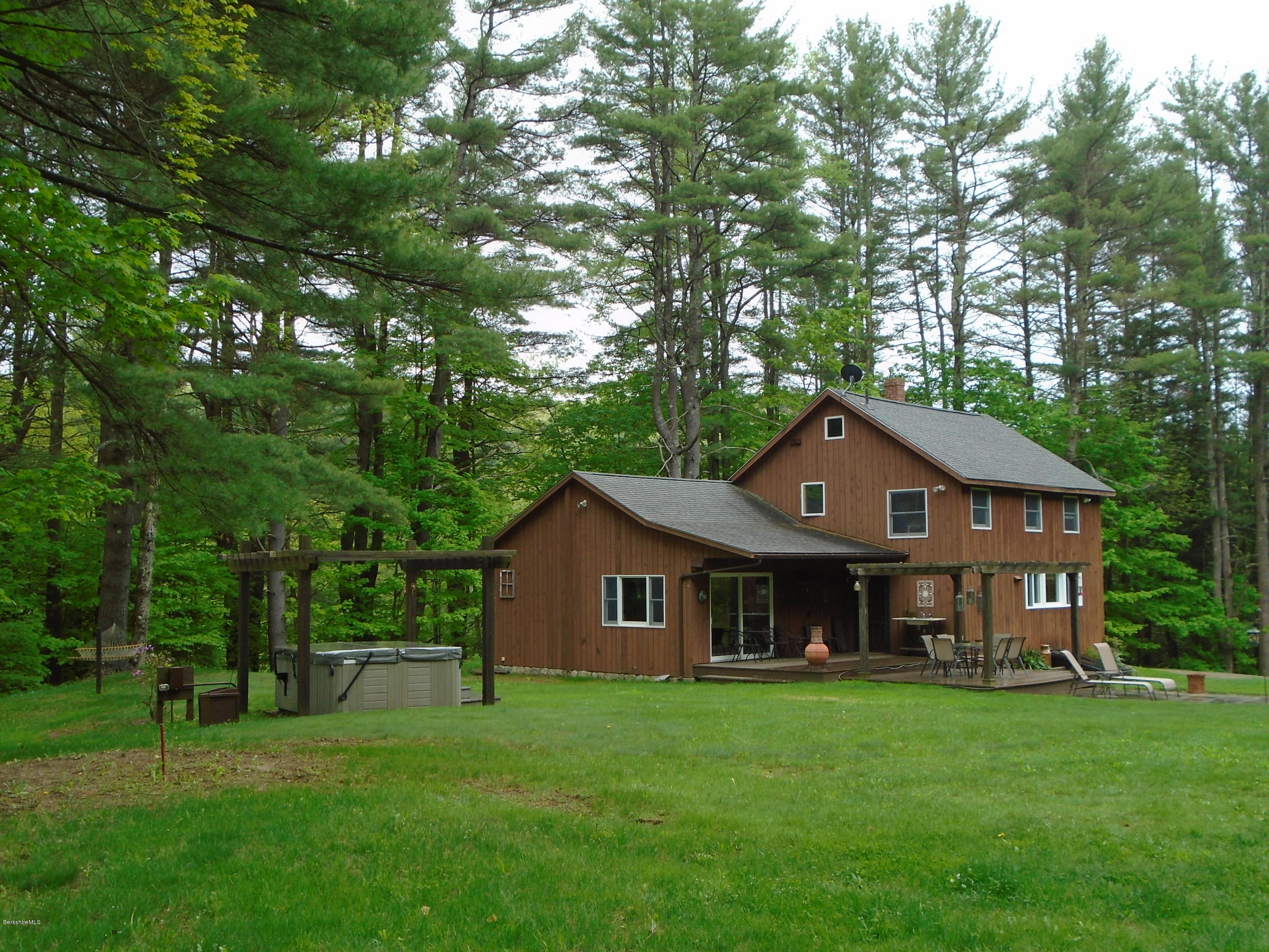 1350 South Main Road Otis, MA 01253 - Photo 1 of 56 a front view of a house with a garden and trees