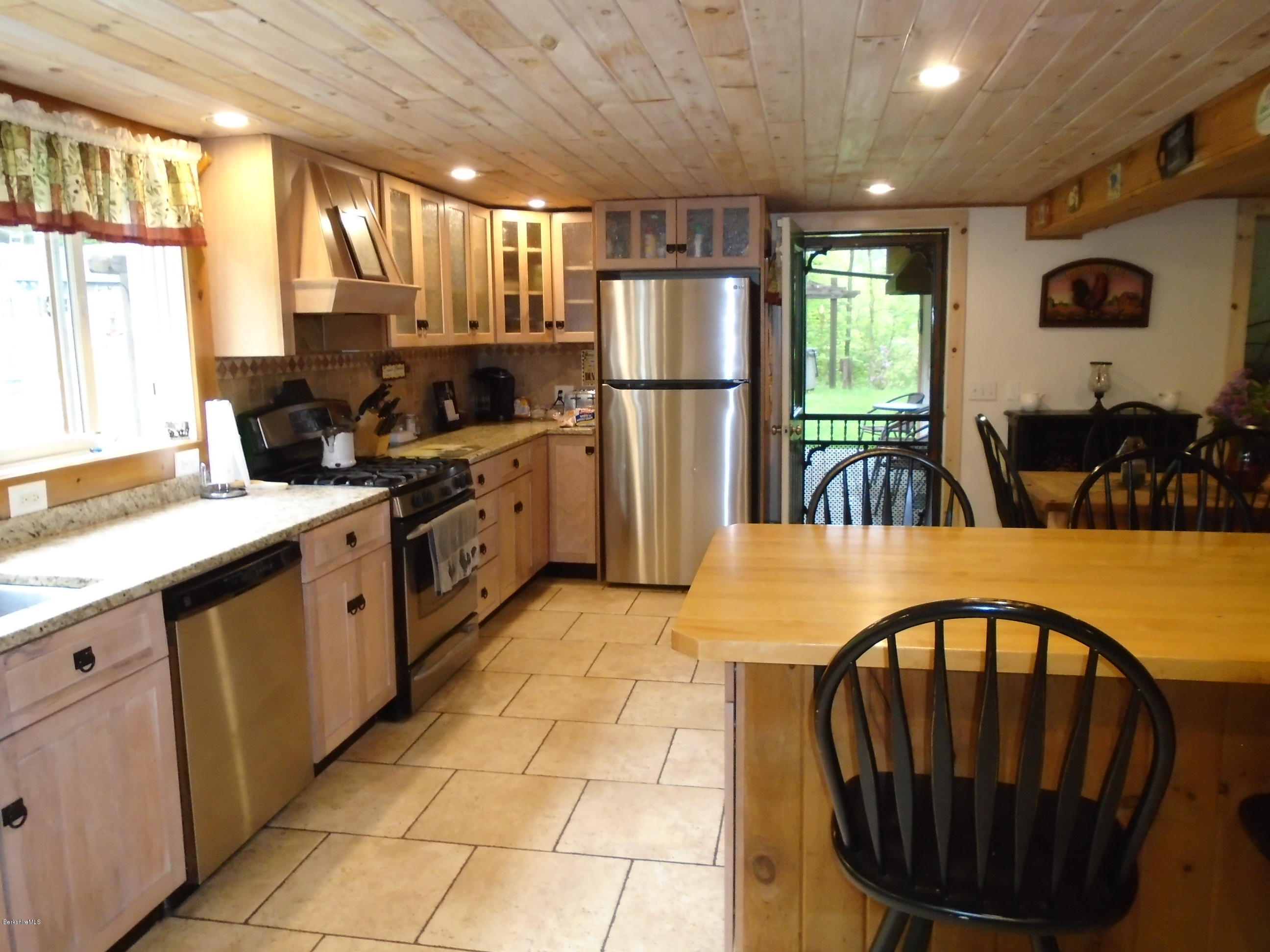 1350 South Main Road Otis, MA 01253 - Photo 11 of 56 a kitchen with stainless steel appliances kitchen island granite countertop a refrigerator a stove a sink dishwasher with a dining table and chairs with wooden floor