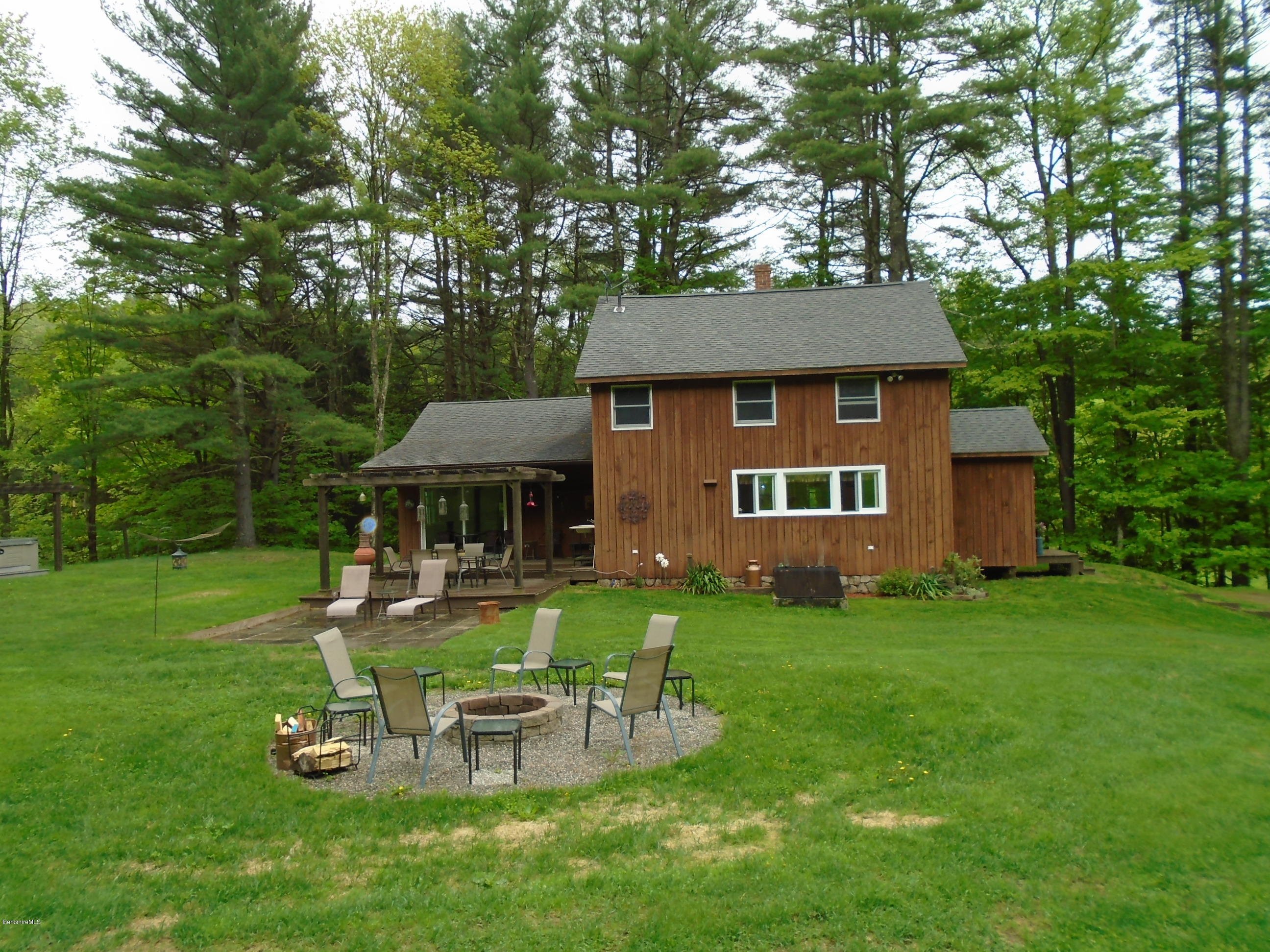 1350 South Main Road Otis, MA 01253 - Photo 3 of 56 a view of a house with backyard sitting area and garden