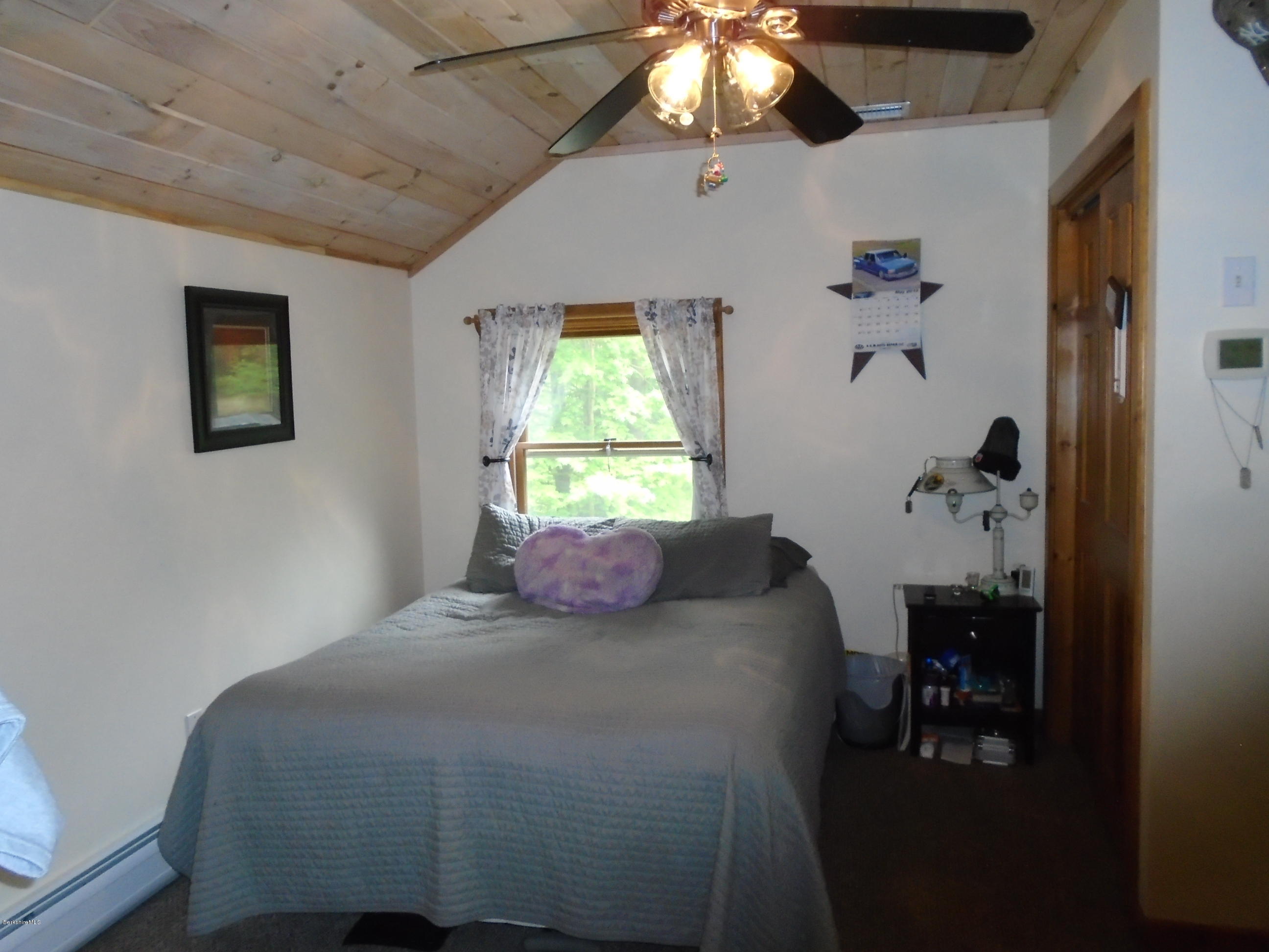 1350 South Main Road Otis, MA 01253 - Photo 42 of 56 a bedroom with a bed and a chandelier