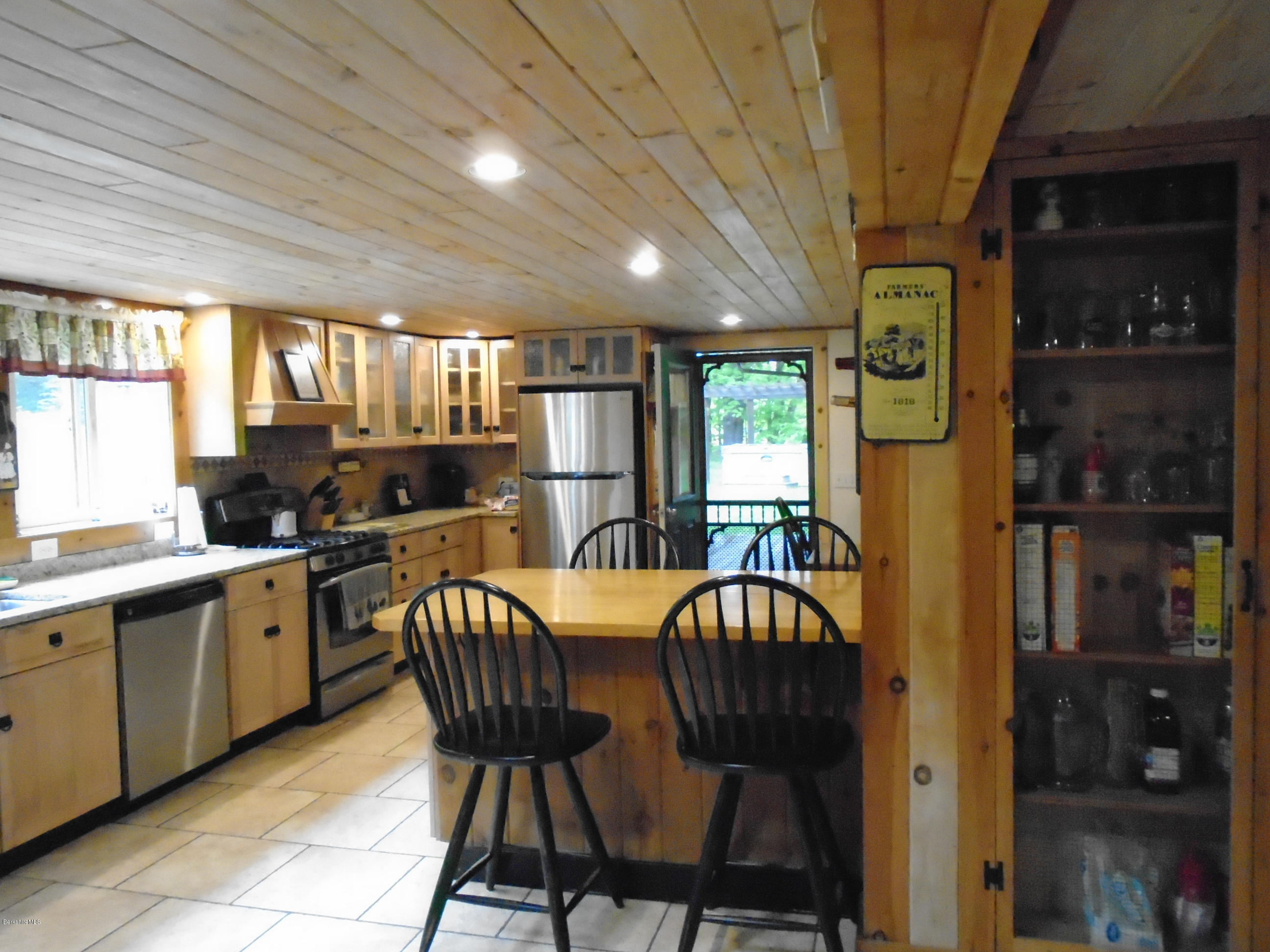 1350 South Main Road Otis, MA 01253 - Photo 10 of 56 a kitchen with a table chairs refrigerator and cabinets