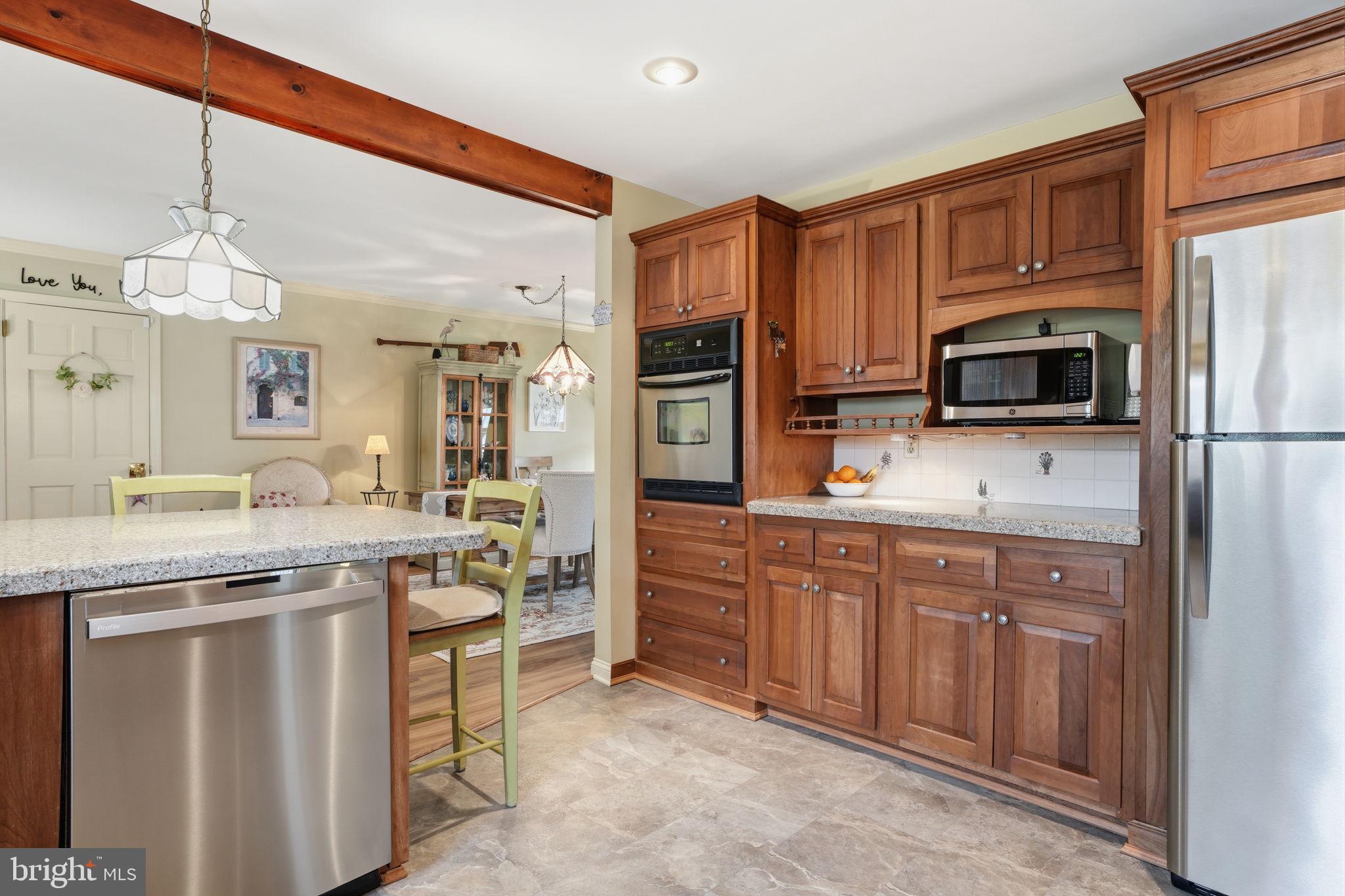 211 Longview Avenue Langhorne, PA 19047 - Photo 16 of 62 a kitchen with stainless steel appliances granite countertop a stove top oven a sink dishwasher a refrigerator and a dining table with wooden floor