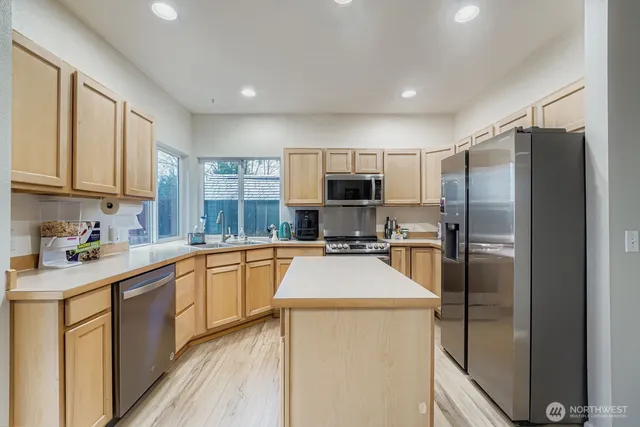 a kitchen with stainless steel appliances granite countertop a refrigerator stove microwave and sink