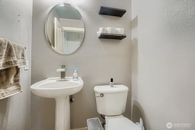 a bathroom with a toilet a sink and a mirror