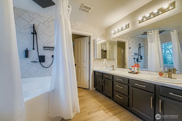 a spacious bathroom with a shower sink and mirror