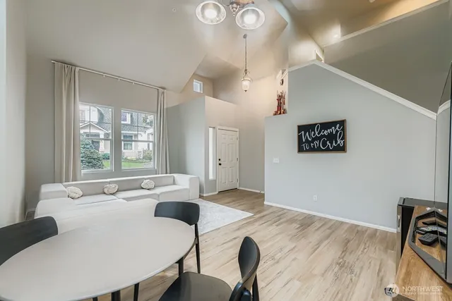 a view of a a dining room with furniture window and wooden floor