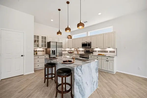 a kitchen with kitchen island a stove a table and chairs