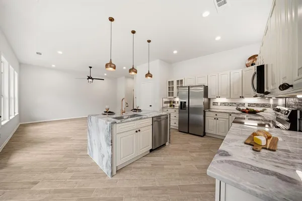 a kitchen with stainless steel appliances granite countertop a sink a stove and a refrigerator
