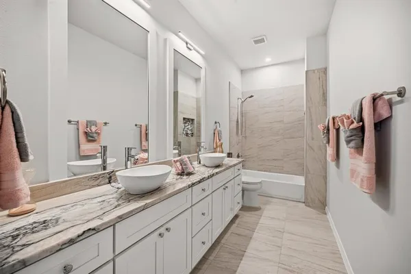a spacious bathroom with a granite countertop sink and a bathtub
