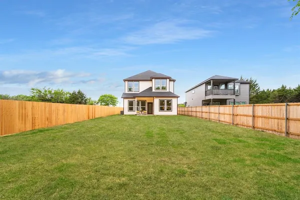 a view of a big house with a big yard and large trees