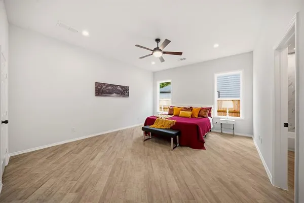 a spacious bedroom with a bed and a ceiling fan