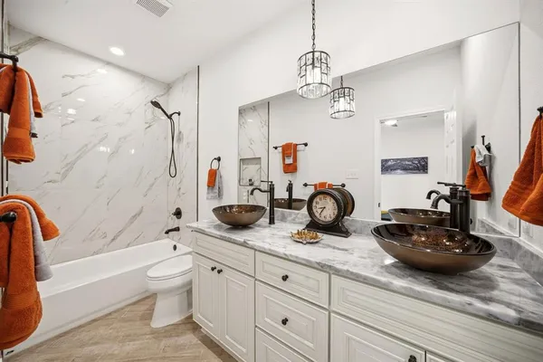 a bathroom with a granite countertop sink a toilet and bathtub