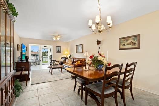 1351 Bayshore Drive, Unit 101 Fort Pierce, FL 34949 - Photo 11 of 37 a dining room with wooden floor a chandelier a wooden table and chairs