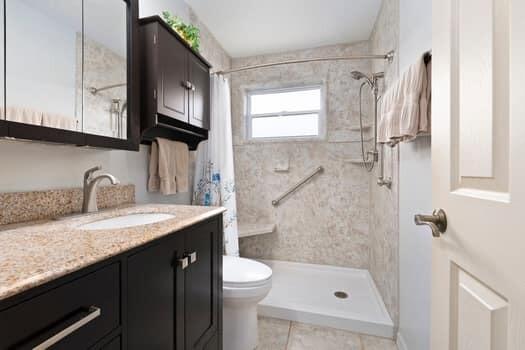 1351 Bayshore Drive, Unit 101 Fort Pierce, FL 34949 - Photo 26 of 37 a bathroom with a granite countertop sink a toilet and shower