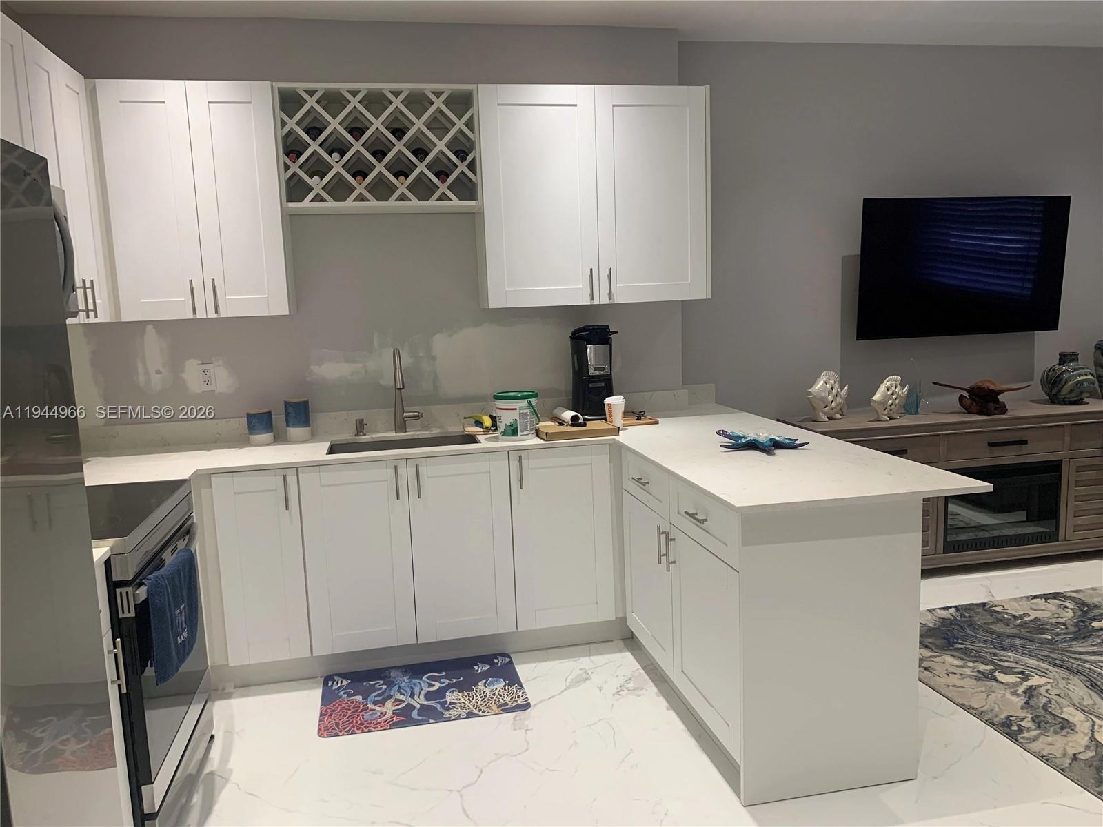 63 Bass Avenue, Unit 1 Key Largo, FL 33037 - Photo 2 of 9 a kitchen with a sink stove and cabinets