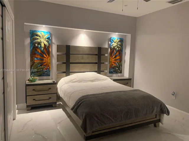 a bed sitting in a bedroom next to a lamp