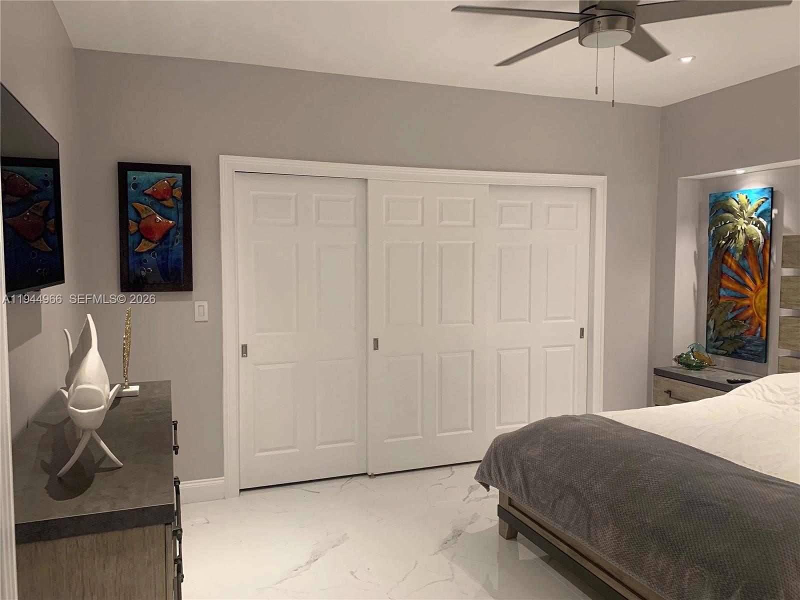 63 Bass Avenue, Unit 1 Key Largo, FL 33037 - Photo 7 of 9 a bedroom with a bed and a chandelier