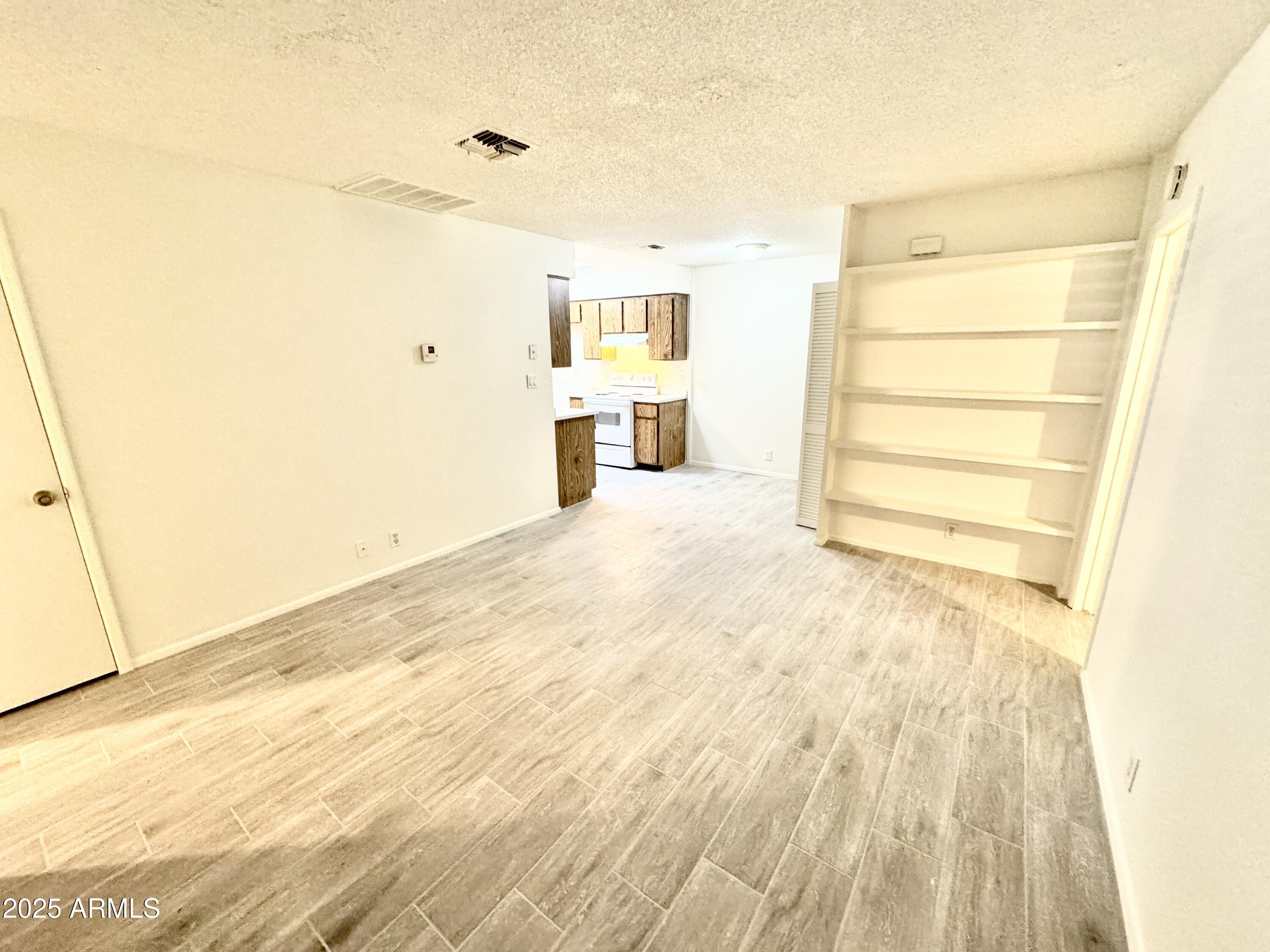 9015 West Elm Street, Unit 2 Phoenix, AZ 85037 - Photo 3 of 32 a view of a bedroom with wooden floor and bathroom