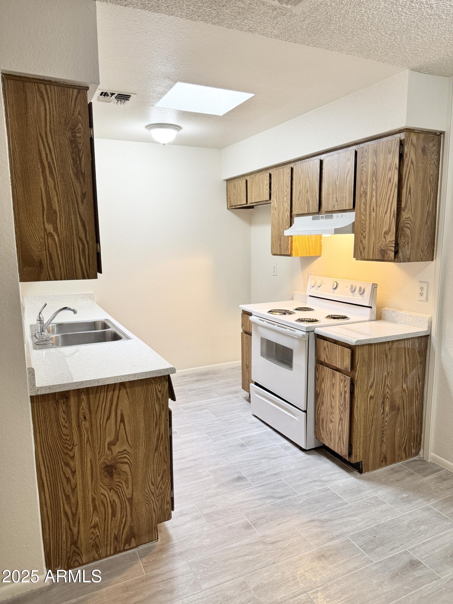 9015 West Elm Street, Unit 2 Phoenix, AZ 85037 - Photo 5 of 32 a kitchen with a stove a sink and a refrigerator