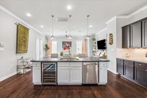 a kitchen with stainless steel appliances kitchen island granite countertop furniture wooden floor and a view of living room